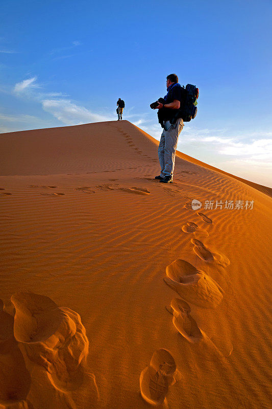 在非洲摩洛哥日出的Erg Chebbi沙丘上的男人